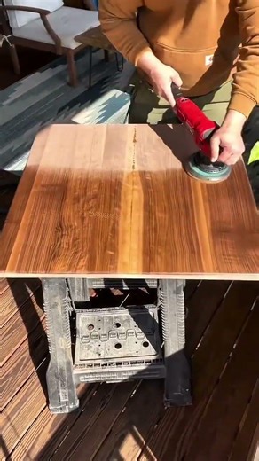 Woodworker Sanding Large Walnut Tabletop To Create A Smooth And Polished Finish