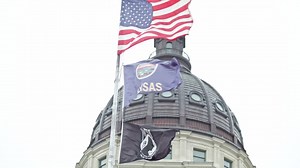 Kansas state capitol building with flags waving in Topeka, Kansas with close up of flags stable video | Premium Stock Video Footage