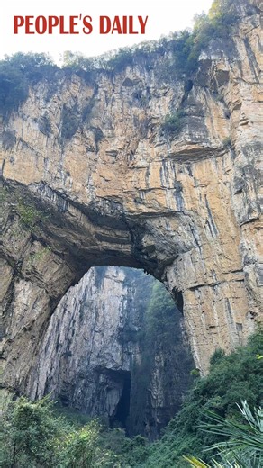 Standing majestic amid the karst landscape, the Tiansheng Bridge, a naturally formed stone arch, is a fascinating masterpiece of nature in Zhijin Grand Canyon of southwest China's Guizhou. | VideoChina
