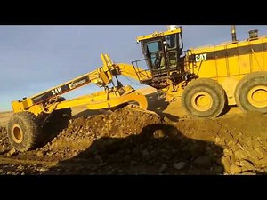 CAT 24 Grader Trimming Rock Slope