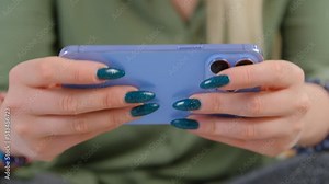 Mobile gamer girl playing games on smartphone. Female person plays on modern mobile phone gadget