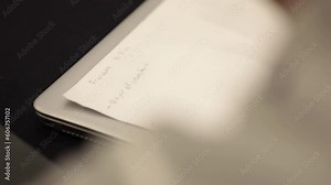 Applied person jotting down notes in the diary by hand. Close up