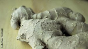 Ginger root extreme close up shot at wooden bowl. Ginger or ginger root is the rhizome of the plant Zingiber officinale, consumed as a delicacy, medicine, or spice. Stock Video