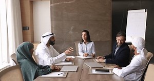 clip-3574638265-serious-european-arabic-business-partners-talking-large