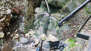 Water pipe accident captured Intense burst from leaking pipe amidst stones urgent accident response needed Pipe accident scene closeup highlighting emergency Leaking pipe accident critical situation