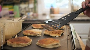 Woman flipping pancakes for breakfast in slow motion