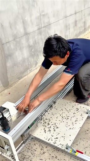 operating a manual precision tile cutting machine to slice large ceramic tiles for home renovation