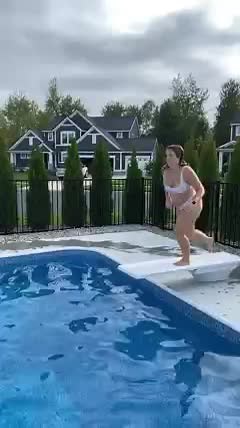 Woman Jumps into Swimming Pool on Cloudy Day
