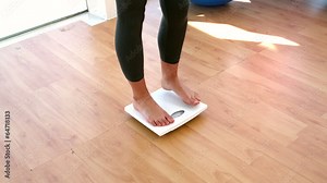 Woman stepping on scales