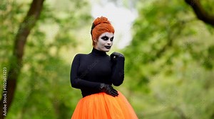 Skeletal makeup and black clothes combined with orange details create a bright and creepy Halloween look.
