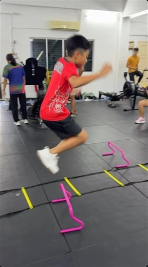 Training in the gym with bodyweight exercises, mini hurdles, and plyometric box jumps