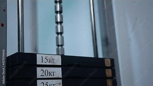 Weight falling in block machine and cloud of powder raising in gym in slo-mo. Load the iron pancakes sports trainer