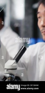 Vertical video Clinical microbiologist examining microscope glass slide in laboratory to view cells. Asian lab worker checks sample slide before imaging process using optical device, camera B Stock Video Footage - Alamy