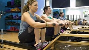 Four people using rowing machines