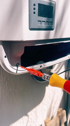 Adjusting a White Electrical Box with a Screwdriver