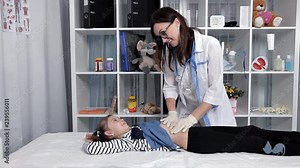 Pediatrician doing abdominal examination with hands.Doctor checking stomach of sick girl