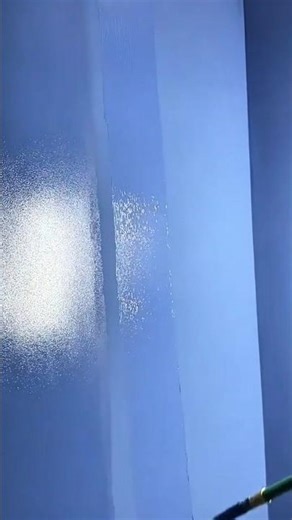 applying light blue paint onto the wall surface using a professional manual long roller tool