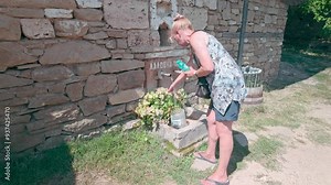 Woman cools off using village refreshing fresh drinking spring water