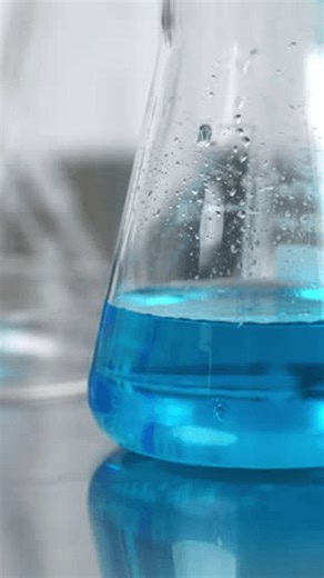 clip-4045397785-scientist-shaking-blue-liquid-erlenmeyer-flask-during