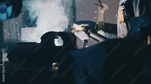 Welding in the Engineering Workshop. Welding sparks, slow motion. A worker uses a welding machine. Close up of a welding machine in work. Worker welds metal. Macro. 4K