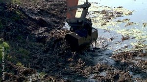 excavator dredge is dredging, working on river, canal, deepening and removing sediment, mud from riverbed in a polluted waterway. Large excavators engaged in cleaning of the riverbed of a river from t