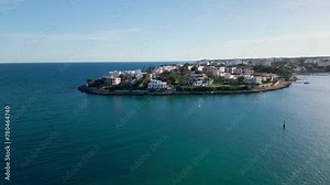 Luxury Real estates at Tranquil Porto Colom bay, Mallorca, with clear blue waters.