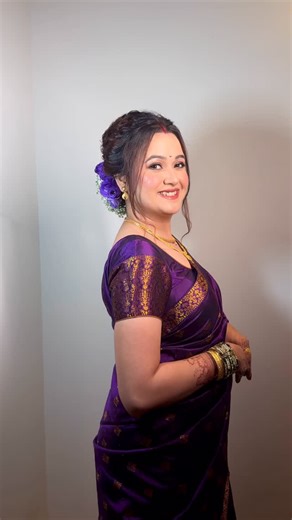 Makeup Artist Nashik on Instagram: "Draped in regal purple, the Assamese bride embraces a subtle Maharashtrian touch at her reception Her flawless base, glowing with perfection, pairs effortlessly with shimmery eyes that catch the light, while nude lips keep the look timeless and refined The rich purple Assam Silk Mekhela Chadar speaks of royalty and grace, beautifully complemented by a purple rose bun base that adds a soft floral charm ✨"