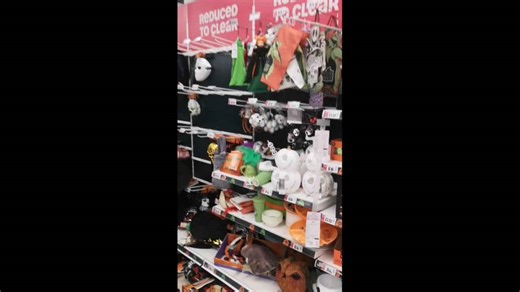 Shelves of discounted Halloween goods are stripped from the shelves by customers at Asda