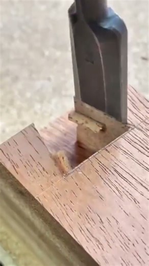 Hand Using Chisel To Carve Dovetail Joint Into Wood