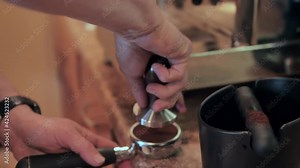 Using a portafilter to make cup of espresso coffee, slow motion close up