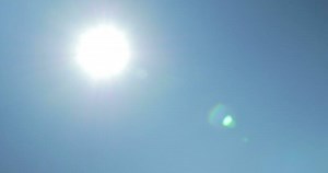 Moving shot from sun to solar panels against blue clear sky