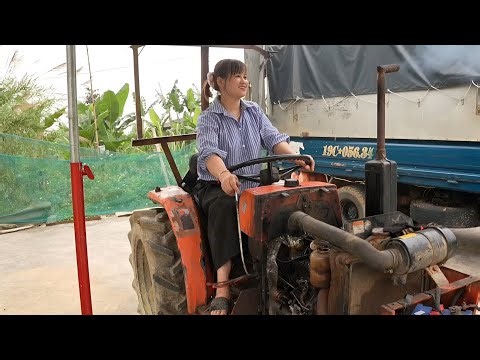 The girl repairs and restores the engine of a broken tractor.