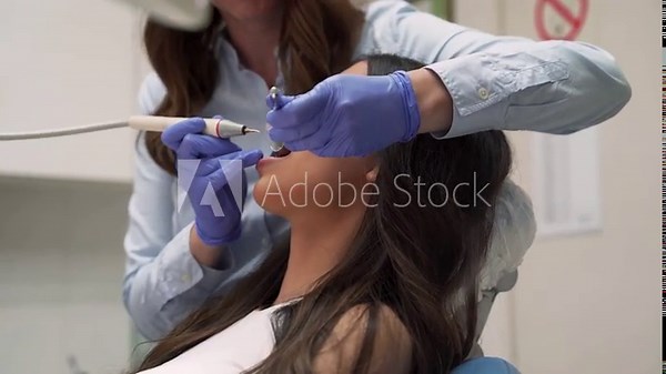 Side view beautiful young woman with dental braces sitting in chair, having dental procedure