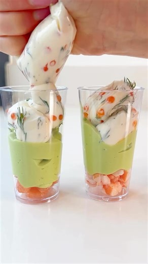 Verrine de crevettes saumon et avocat Pour 8 Ingrédients : - 2 avocats - 2 cuillères à soupe de fromage frais - Jus d’un citron - 2 cuillères à soupe de fromage frais (pour la seconde préparation) - 1 cuillère à soupe d’œufs de poisson (ou d’œufs de truite) - Aneth ou ciboulette - Petits morceaux de saumon fumé - Petits morceaux de crevettes Instructions : 1. Préparation de l’avocat : Dans un mixeur, ajoutez les 2 avocats, 2 cuillères à soupe de fromage frais, et le jus d’un citron. Mixez jusqu’