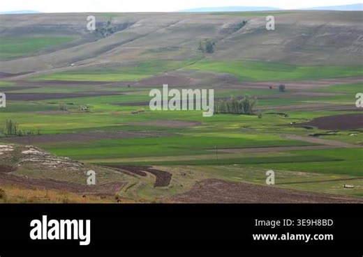 Meandering river winds through green farmland valley, panoramic rural landscape with rolling hills. Winding stream curves across patchwork fields and meadow plain, scenic countryside terrain unfolds Stock Video Footage - Alamy