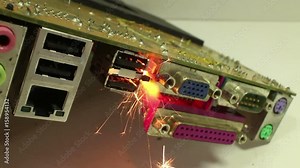MCU dolly back and forth near sparkling, burning computer component; various jacks and ethernet sockets visible. One of a series