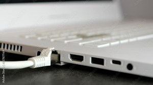 Inserting a cable Ethernet to the port laptop - connecting and disconnecting router into computer. Access to internet in computer by cable rj45 - LAN