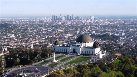 Griffith Observatory overlooking downtown Los Angeles California. City Horizon on a clear sunny day. Fenced off lawn with no people on perfect grass. Zoomed in for Bigger effect in 4k