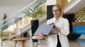 Confident blonde businesswoman in the lobby of a modern business hotel. An independent, confident female executive enjoying a successful corporate career.