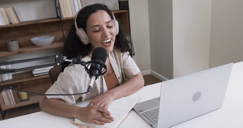 clip-4008556651-african-descent-woman-leaning-mic-desk-speaking