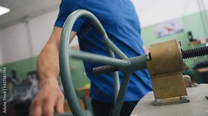 The worker rotates the valve on the test bench to check the part. Close-up of the mechanism and hands