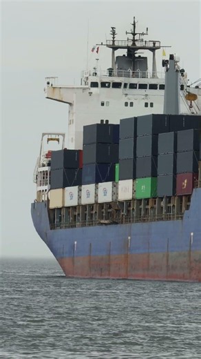 A bulk carrier loaded with containers is being pushed by a tugboat #ship