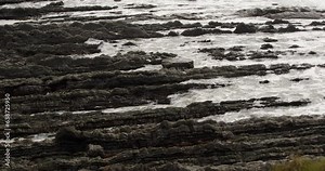 mid shot of waves rolling onto sedimentary rocks at Hartland Quay, Stoke, Hartland, Bideford