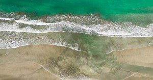 Aerial View of Waves Meeting Sandy Beach