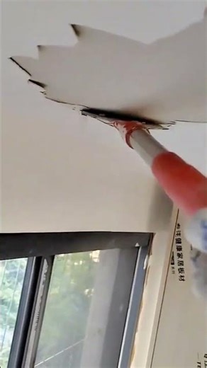 Ceiling drywall removal begins using angled scraping tool effectively