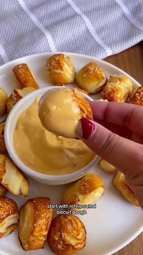 Homemade Pretzel Bites made with store-bought biscuit dough by @Genie 🤩 Now THIS is a hack we can get behind! Find the full recipe below: INGREDIENTS: 1 8 count refrigerated flaky biscuits Coarse salt 2 tbsp melted butter 1/4 cup baking soda 8 cups water STEPS: 1. Preheat oven to 425F and cut each biscuit into 6 individual pieces 2. Bring water to a boil and slowly add in baking soda 3. Add in biscuit pieces a couple at a time for 20-30 seconds then place onto a parchment lined sheet pan 4. Bru