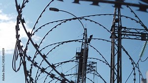 Barbed wire on the fence of a sensitive facility. Barbed wire at the border. Secret, restricted area fenced with barbed wire. Barbed wire at the border.