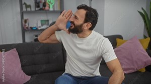Frustrated middle-age man yelling at open space indoors, using hand as a loudspeaker for his rage-filled communication