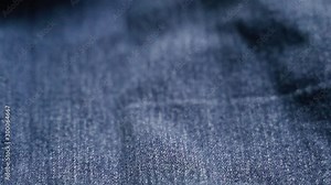 Blue jeans Fabric texture. can use as background. close-up of denim , SLOW Motion , texture of the material from the color of dark blue jeans with patches,