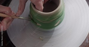 Potter carves a pattern on a rotating jug, potter's wheel at workshop, potter makes ceramics in slow motion, 4k 60p Prores HQ 10 bit Stock Video